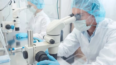 Pharmazeutischer Laborant schaut in ein Mikroskop